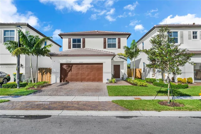 a front view of a house with a yard and garage