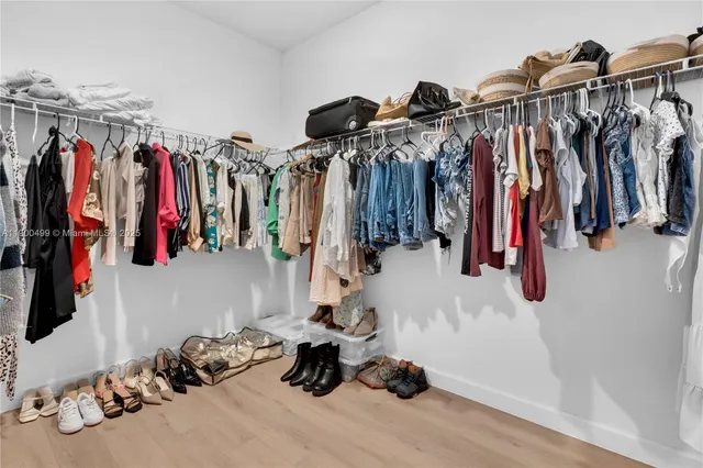 a view of walk in closet with clothes