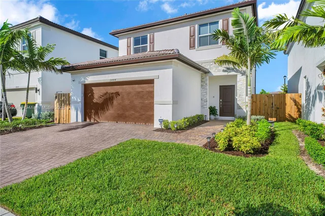 a front view of a house with a garden and plants