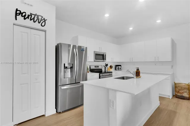 a kitchen with a refrigerator sink and cabinets