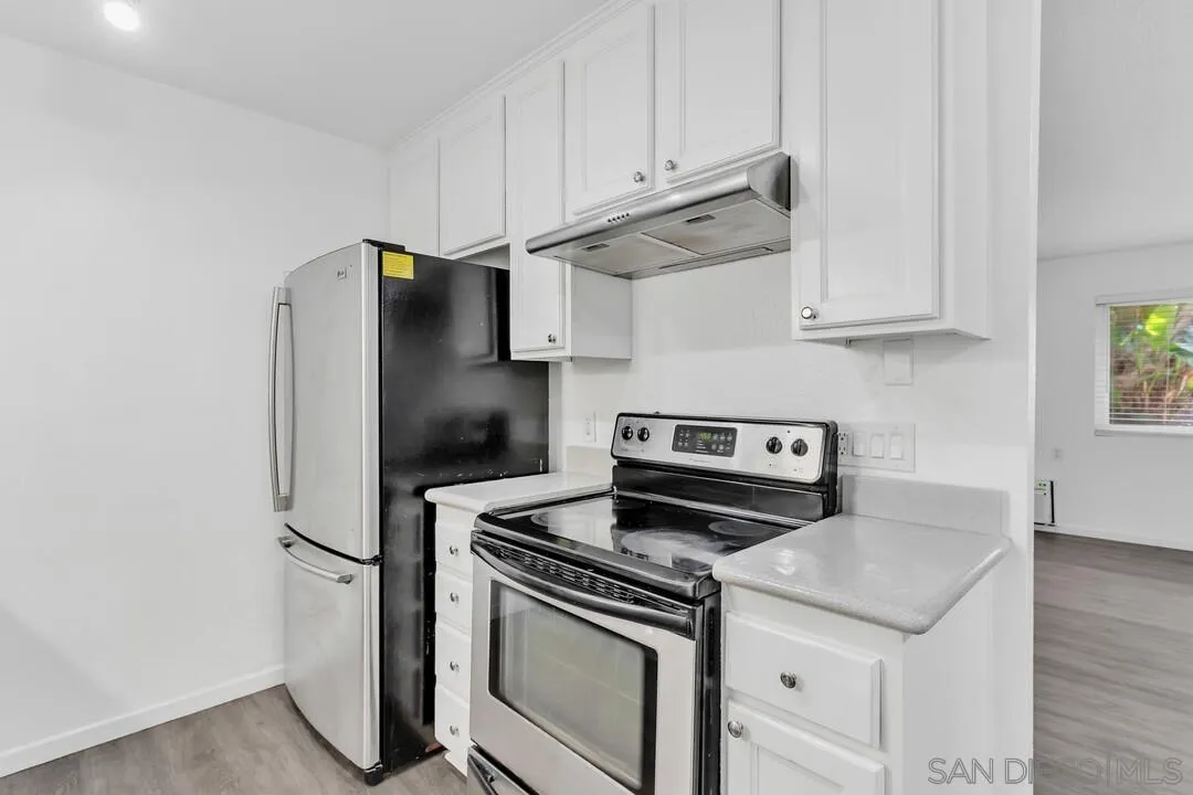 9860 Dale Avenue, Unit A12 Spring Valley, CA 91977 - Photo 11 of 28 a kitchen with stainless steel appliances white cabinets and a stove top oven
