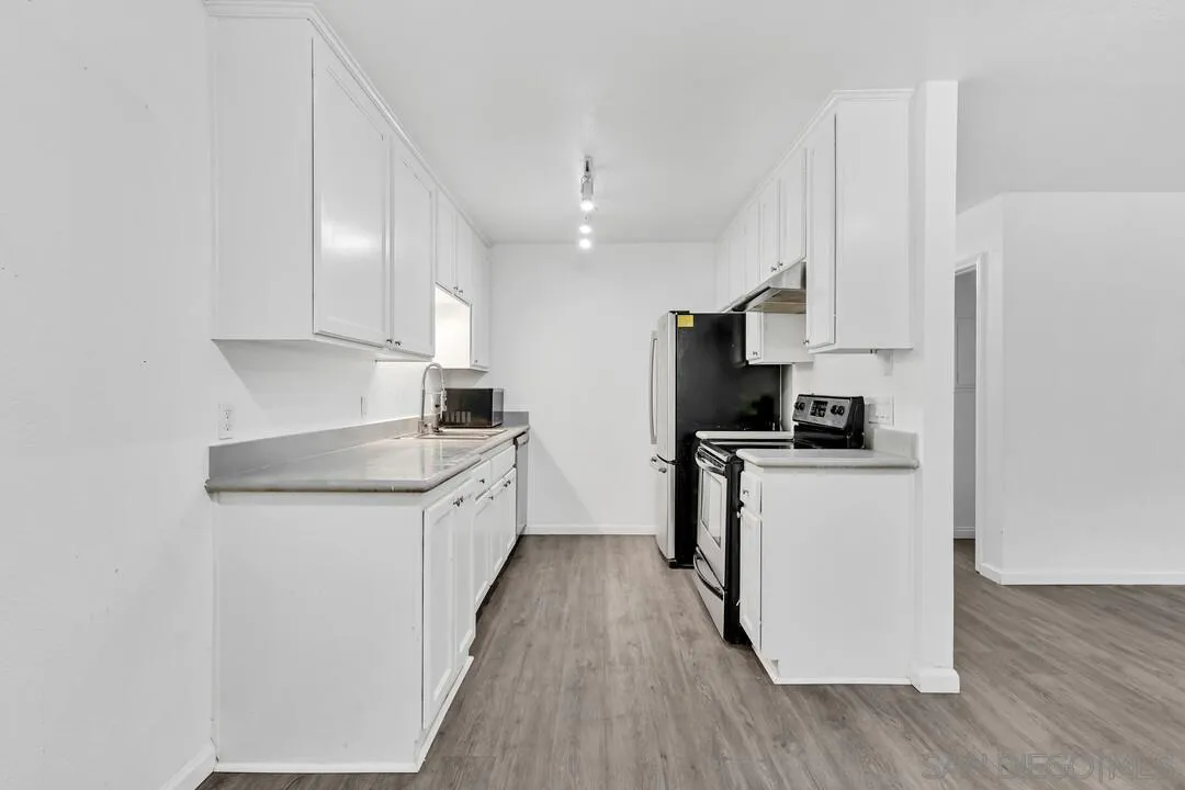 9860 Dale Avenue, Unit A12 Spring Valley, CA 91977 - Photo 12 of 28 a kitchen with a sink a counter top space stainless steel appliances and a window