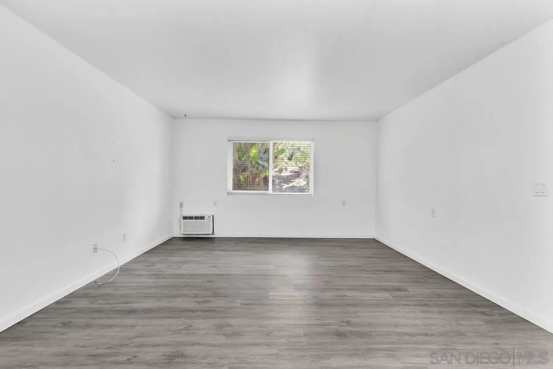 9860 Dale Avenue, Unit A12 Spring Valley, CA 91977 - Photo 8 of 28 a view of an empty room with wooden floor and a window