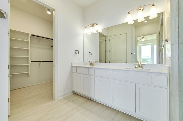 19005 Fernando Trail Austin, TX 78738 - Photo 11 of 26 Full bathroom with double vanity, light wood-style floors, and a big walk in closet