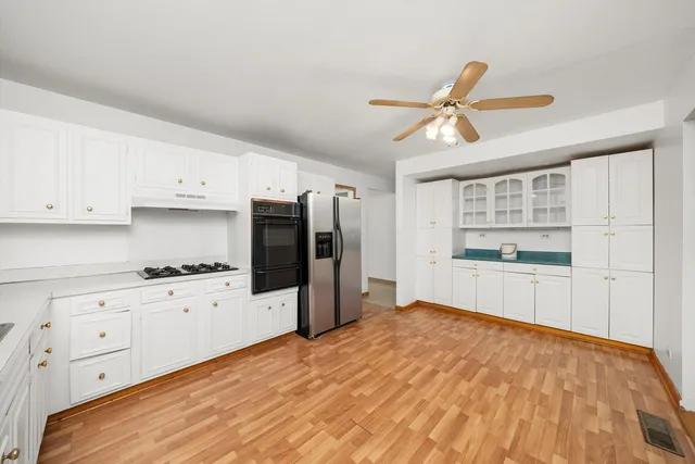 a kitchen with granite countertop white cabinets and stainless steel appliances