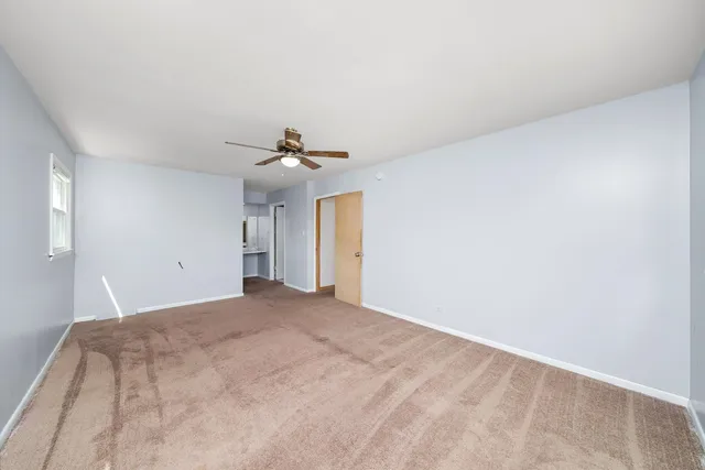 a view of a big room with windows and chandelier fan