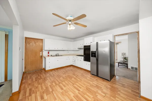 a view of a kitchen with a cabinet and stainless steel appliances