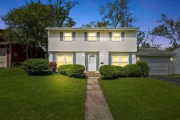 a front view of a house with a garden and yard