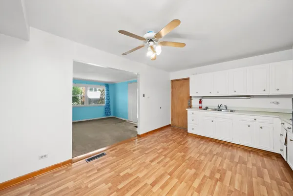 a view of a livingroom with wooden floor and a ceiling fan