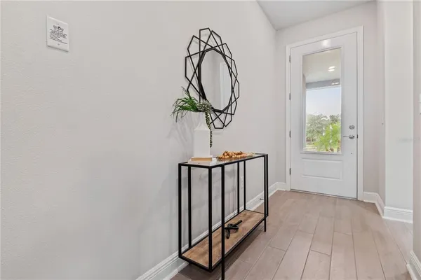 a view of a hallway with wooden floor and entryway