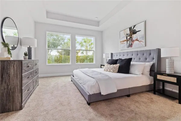 a spacious bedroom with a bed a dresser and next to a window