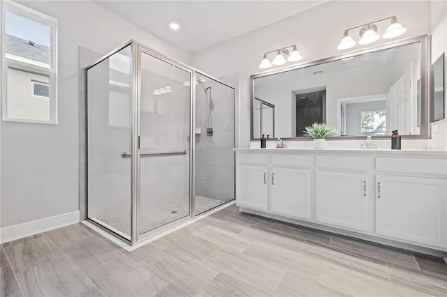 a spacious bathroom with a shower sink and mirror