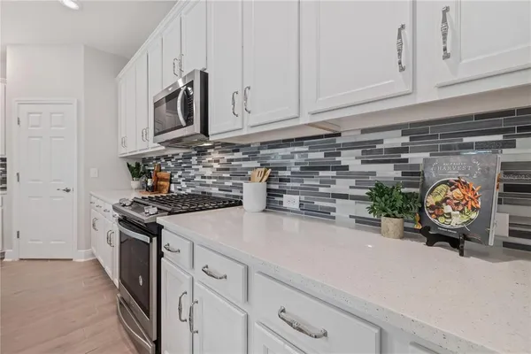 a kitchen with stainless steel appliances white cabinets and a stove