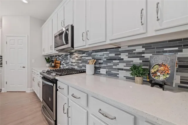 a kitchen with stainless steel appliances white cabinets and a stove
