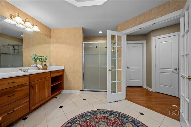 a spacious bathroom with a mirror a sink and shower