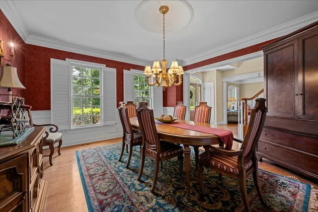 a dining room with furniture a chandelier and wooden floor