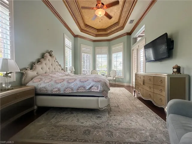 a spacious bedroom with a bed and a flat screen tv