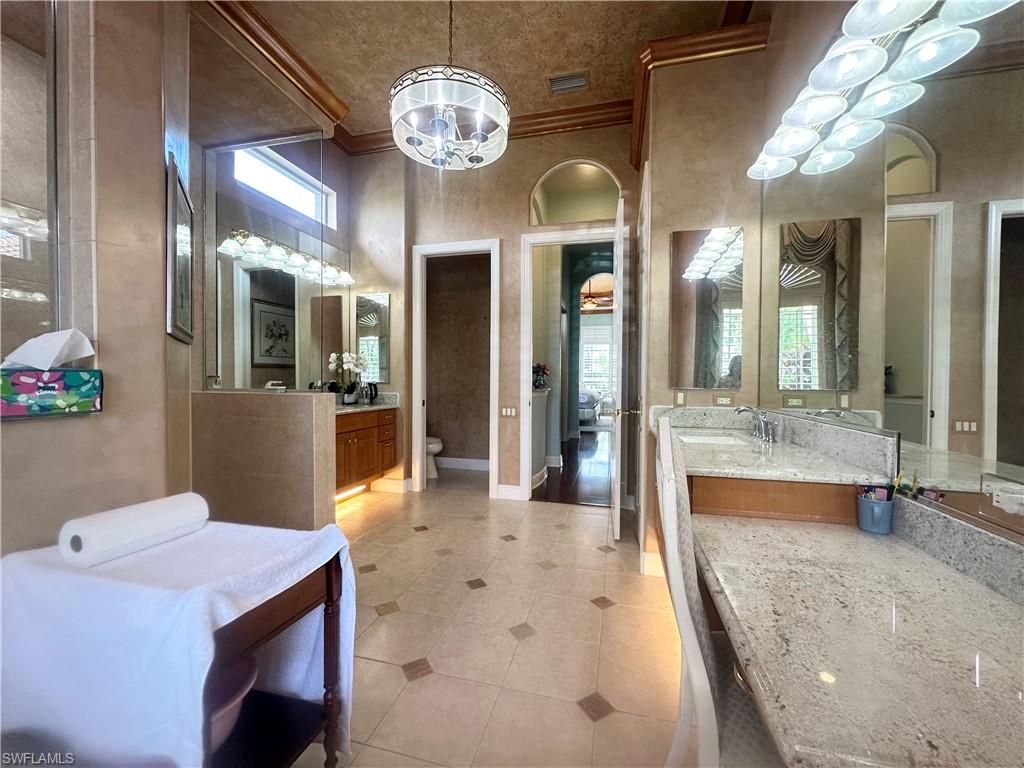 8411 Mallow Lane Naples, FL 34113 - Photo 16 of 31 a view of a dining room with furniture a chandelier and wooden floor