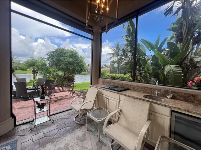 a patio with table and chairs and potted plants