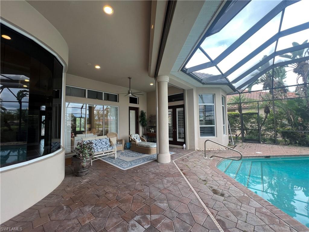 8411 Mallow Lane Naples, FL 34113 - Photo 27 of 31 a view of a porch with chairs and floor to ceiling window