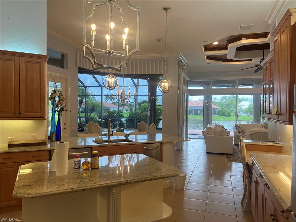 8411 Mallow Lane Naples, FL 34113 - Photo 8 of 31 a dining room with furniture a chandelier and wooden floor
