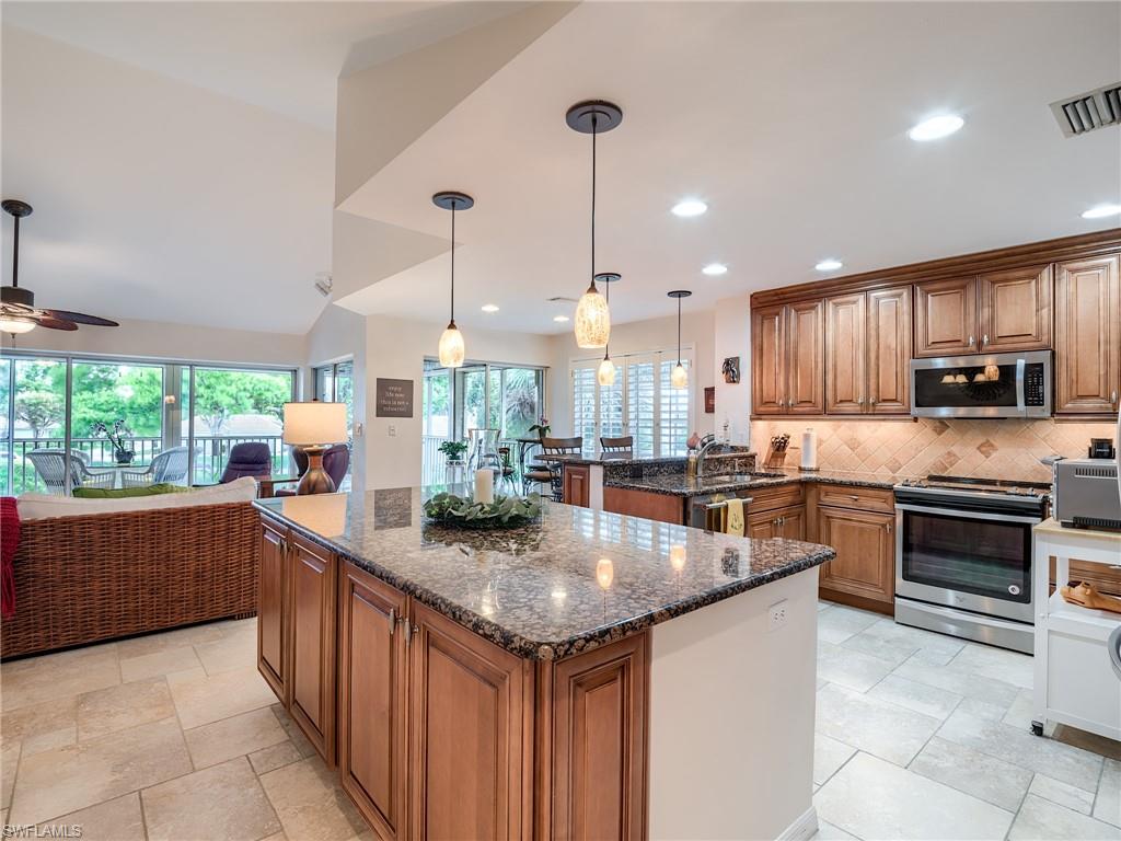 a kitchen with stainless steel appliances granite countertop a sink counter space cabinets and a large window
