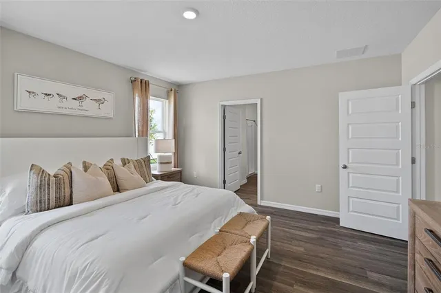 a bedroom with a bed and wooden floor