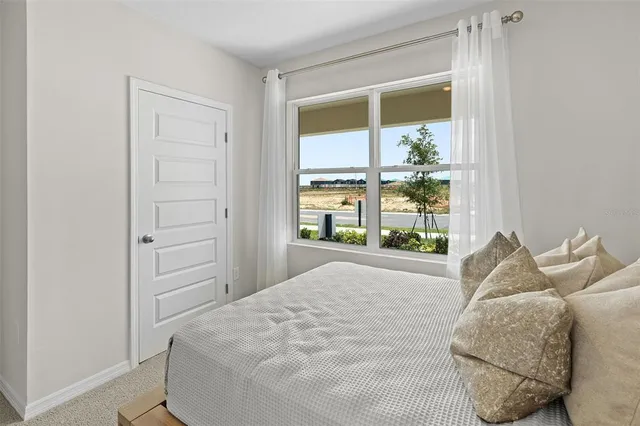 a bed sitting in a bedroom next to a window