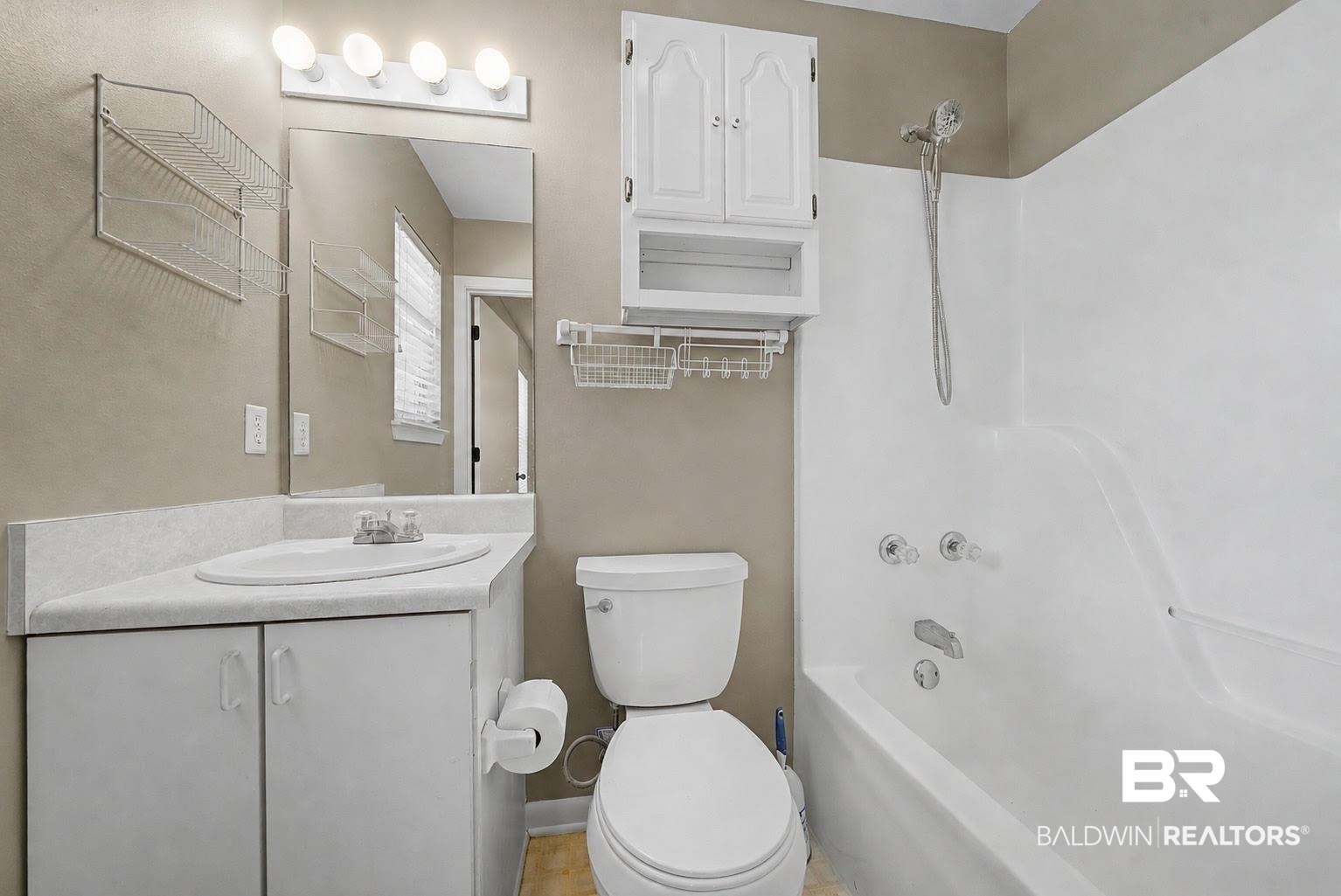 22963 Highway 98 Foley, AL 36535 - Photo 27 of 52 Bathroom featuring a white vanity with integrated sink, a rectangular mirror, a four-light fixture, a toilet, and a white bathtub with shower
