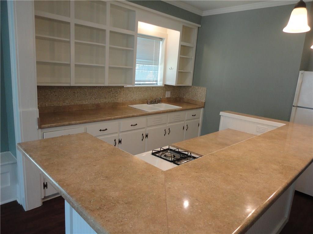 200 East 33rd Street Austin, TX 78705 - Photo 8 of 27 a kitchen with a sink a stove and wooden floor