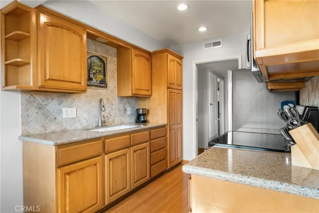 a kitchen with stainless steel appliances granite countertop a sink and a refrigerator