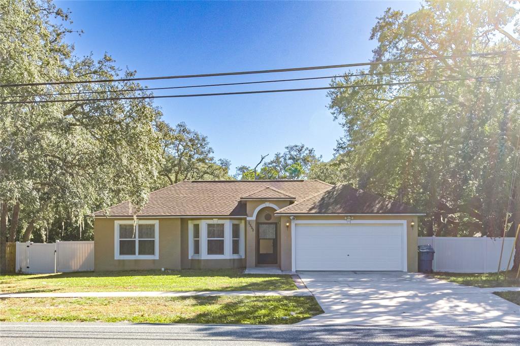 1552 Deltona Boulevard Spring Hill, FL 34606 - Photo 4 of 30 a front view of a house with a yard and garage
