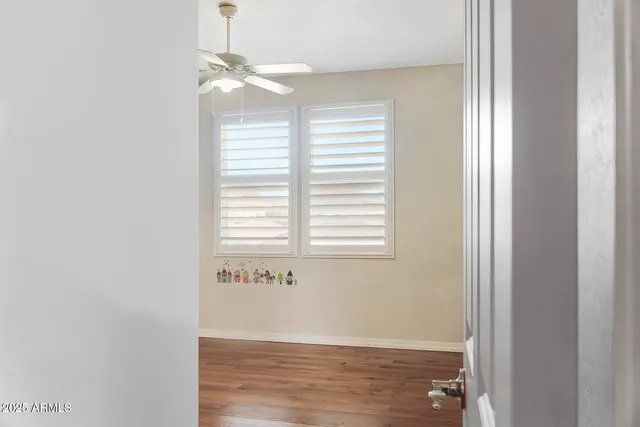 a view of empty room with wooden floor