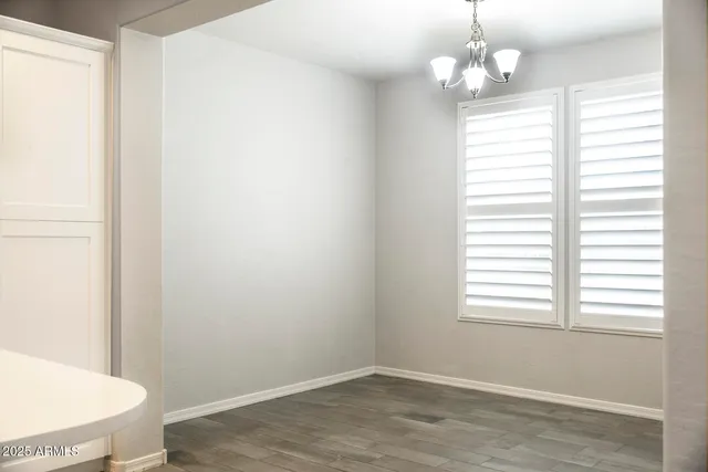 an empty room with windows and ceiling fan