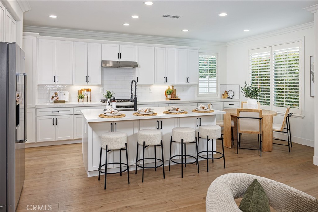 3 Tudor Way Ladera Ranch, CA 92694 - Photo 4 of 25 a kitchen with stainless steel appliances granite countertop a table chairs sink refrigerator and cabinets