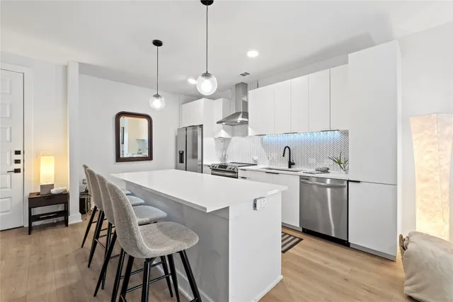 a kitchen with kitchen island a stove a table and chairs in it