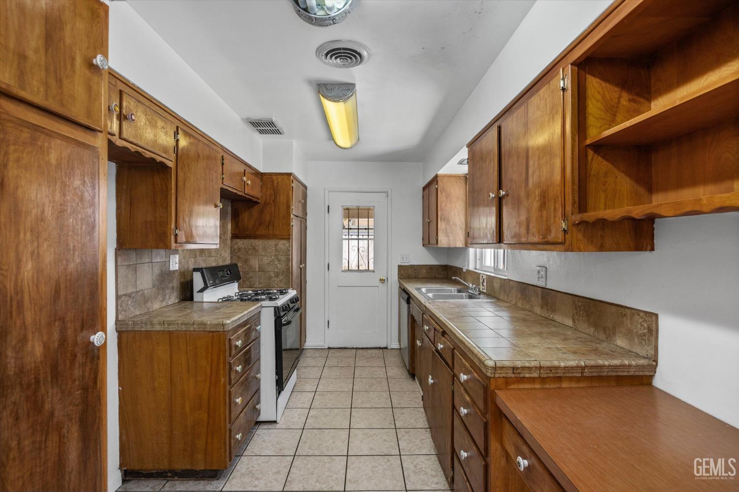 Undisclosed Address Bakersfield, CA 93309 - Photo 11 of 32 a kitchen with a stove a sink and a refrigerator