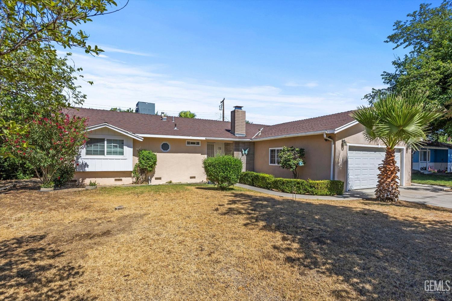 Undisclosed Address Bakersfield, CA 93309 - Photo 3 of 32 a front view of a house with a yard and garage