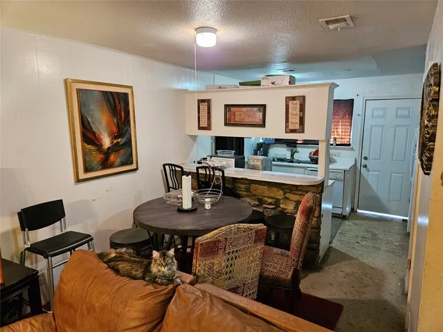 a kitchen with a table chairs cabinets and stainless steel appliances