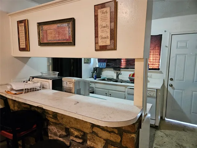 a kitchen with refrigerator a stove a sink and cabinets