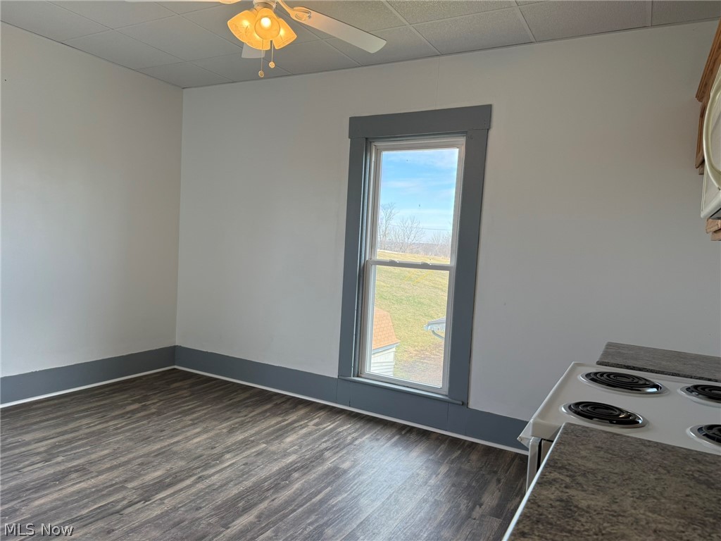 23033 Cadiz Road Freeport, OH 43973 - Photo 24 of 31 Kitchen with white range with electric cooktop, dark wood-style flooring, a ceiling fan, and a drop ceiling