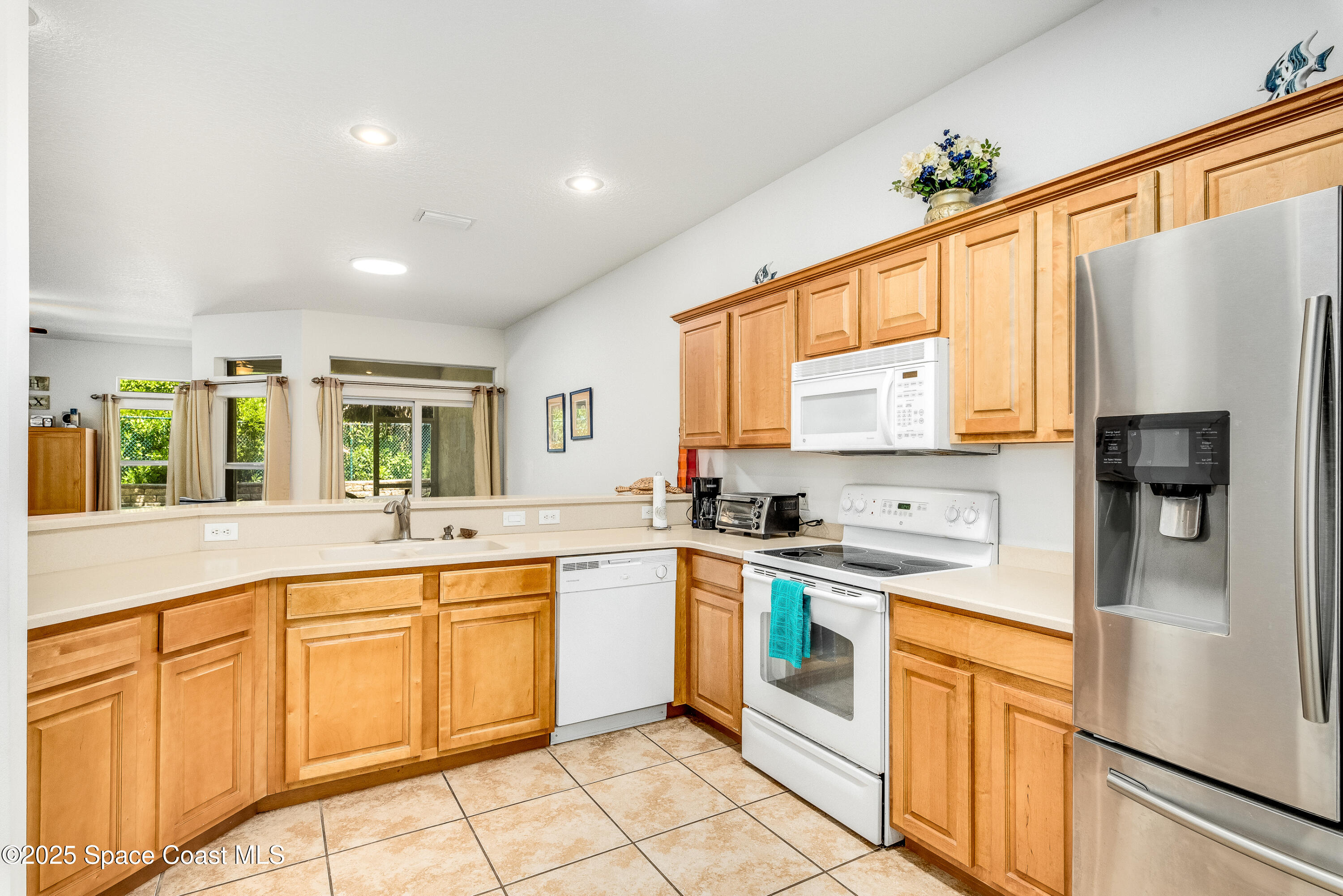 3188 Ricks Way, Unit B Melbourne Beach, FL 32951 - Photo 2 of 58 a kitchen with granite countertop stainless steel appliances a sink cabinets and a window