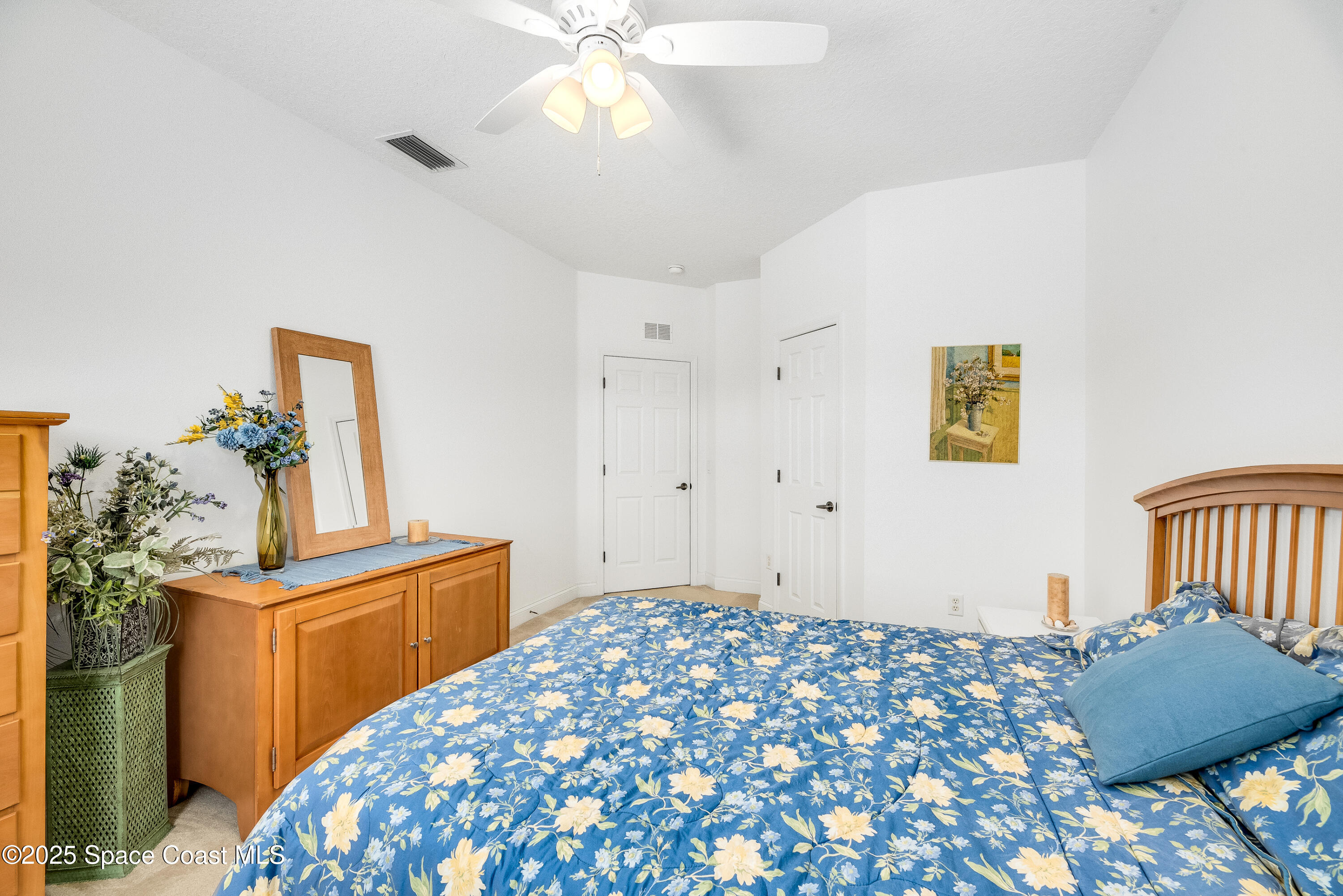 3188 Ricks Way, Unit B Melbourne Beach, FL 32951 - Photo 23 of 58 a bedroom with a bed and a chandelier