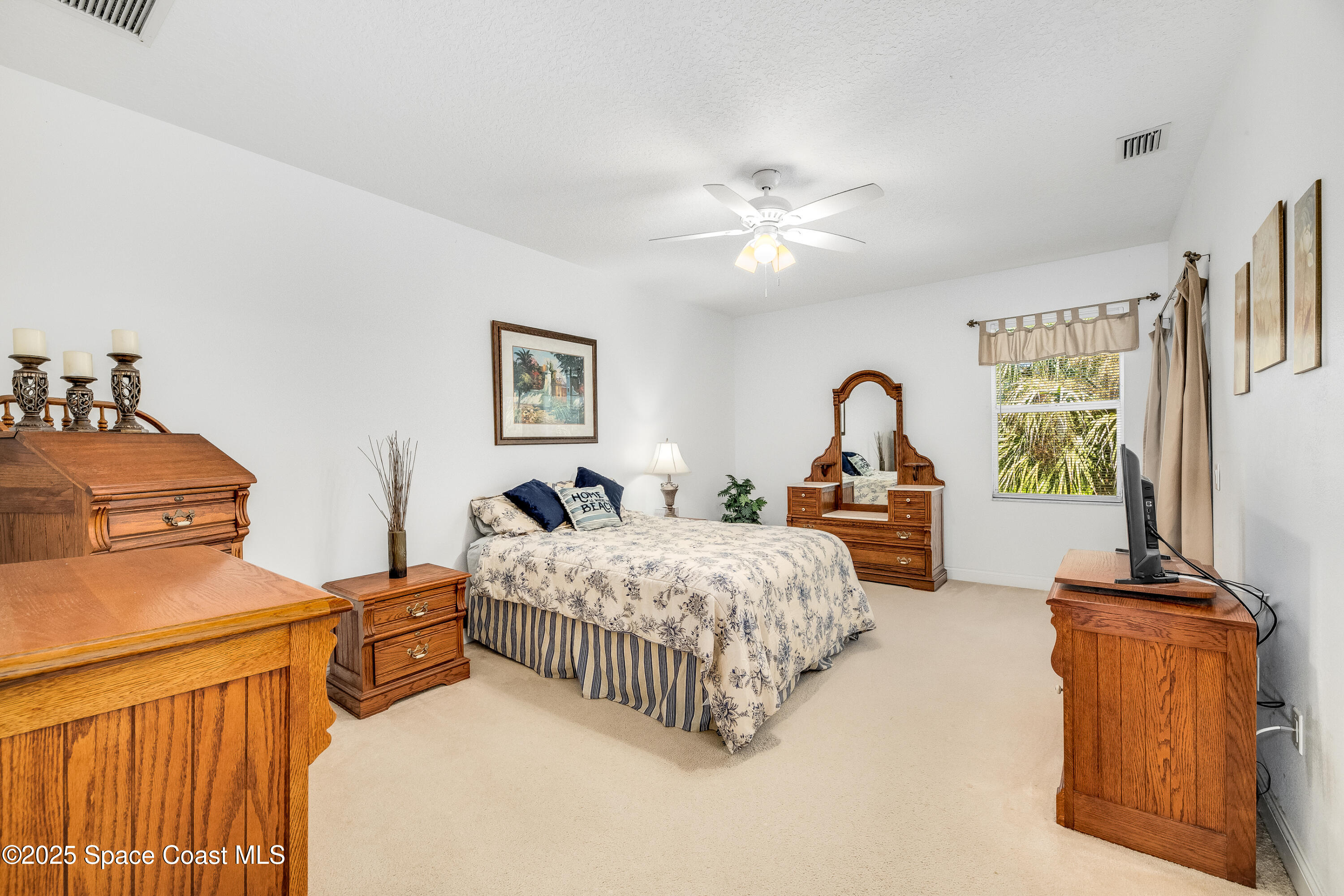 3188 Ricks Way, Unit B Melbourne Beach, FL 32951 - Photo 25 of 58 a bedroom with a bed and a chandelier