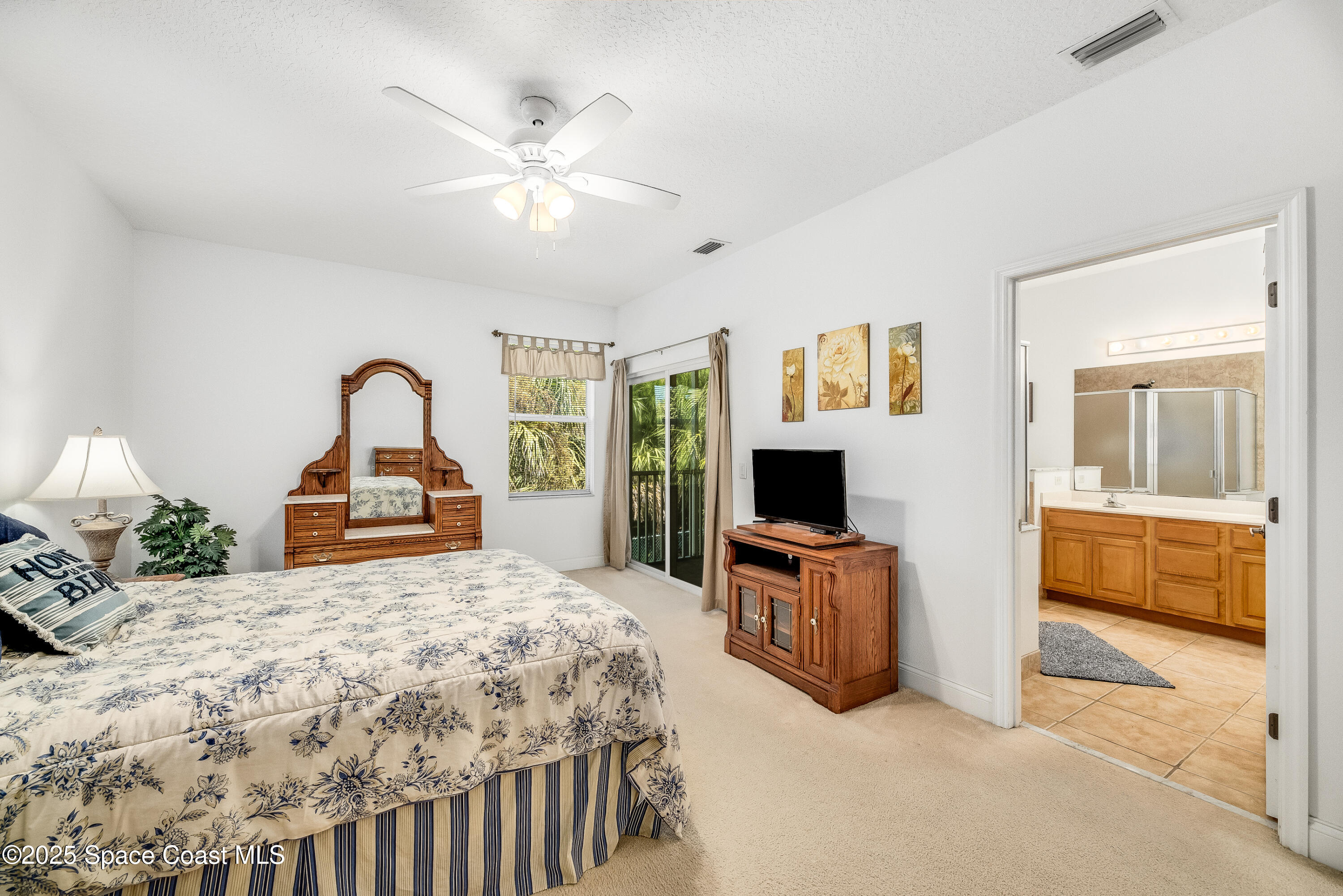 3188 Ricks Way, Unit B Melbourne Beach, FL 32951 - Photo 26 of 58 a bedroom with a bed and a flat screen tv