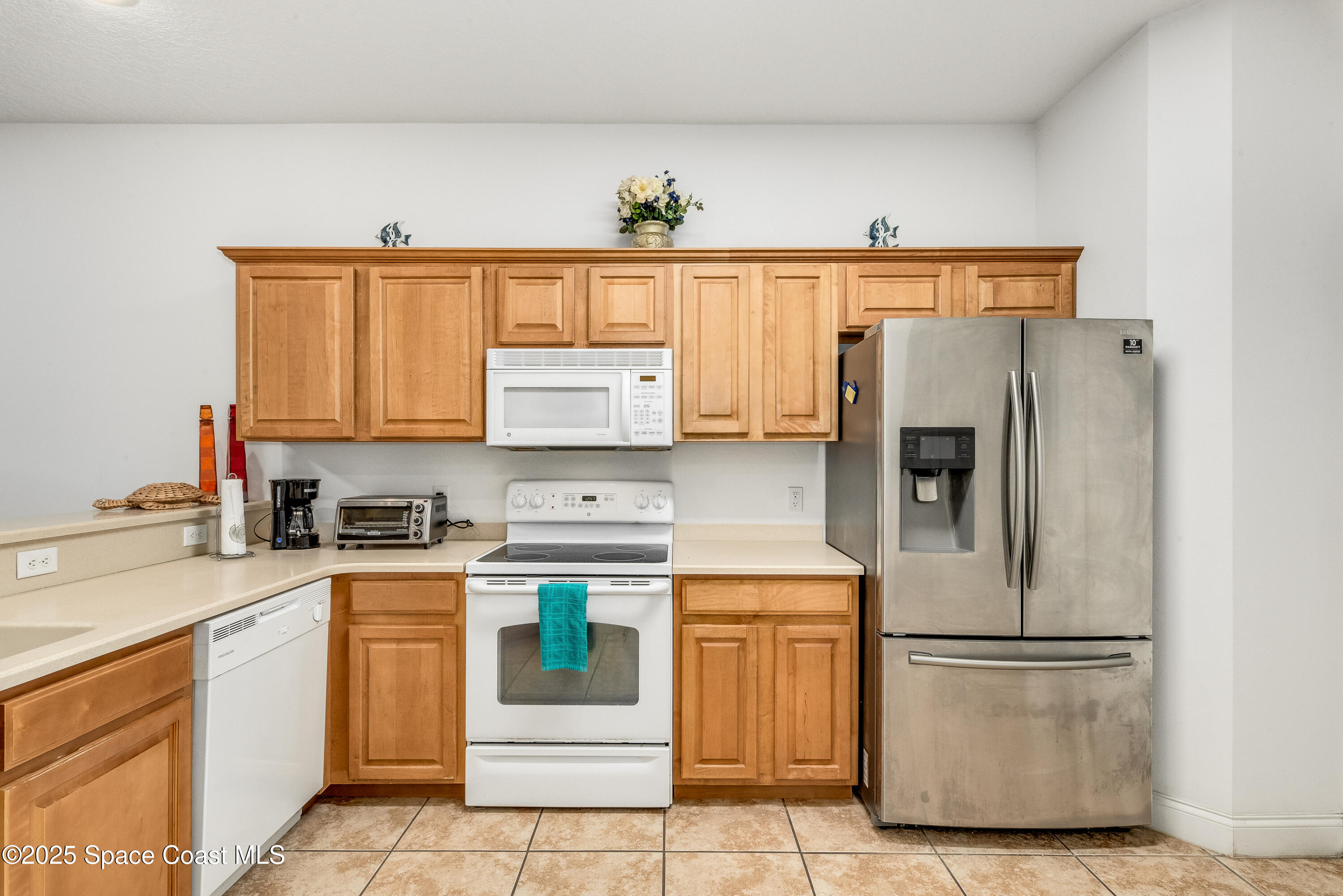 3188 Ricks Way, Unit B Melbourne Beach, FL 32951 - Photo 10 of 58 a kitchen with a refrigerator sink and cabinets