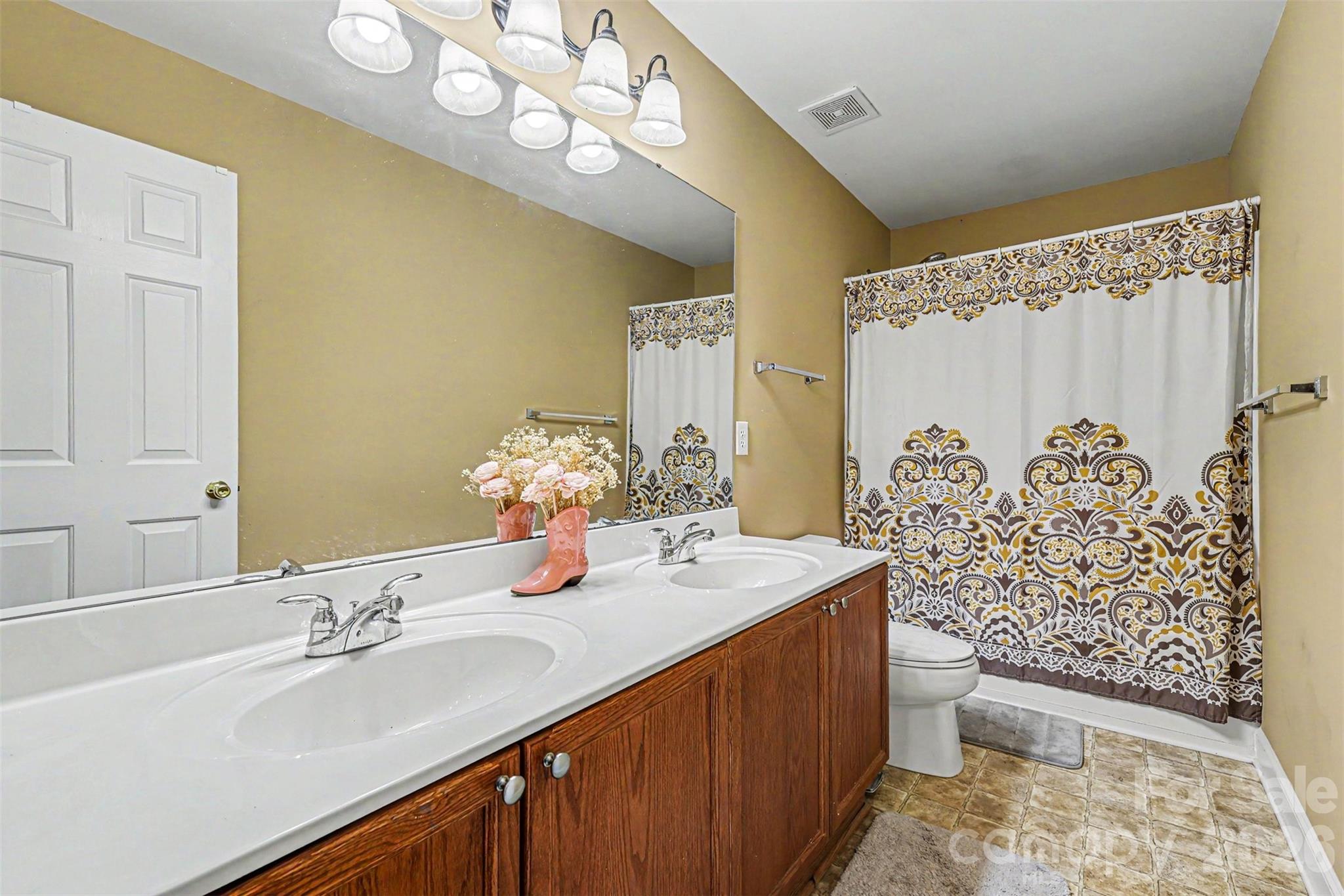 3035 Proverbs Court Monroe, NC 28110 - Photo 27 of 30 a bathroom with a double vanity sink mirror and toilet