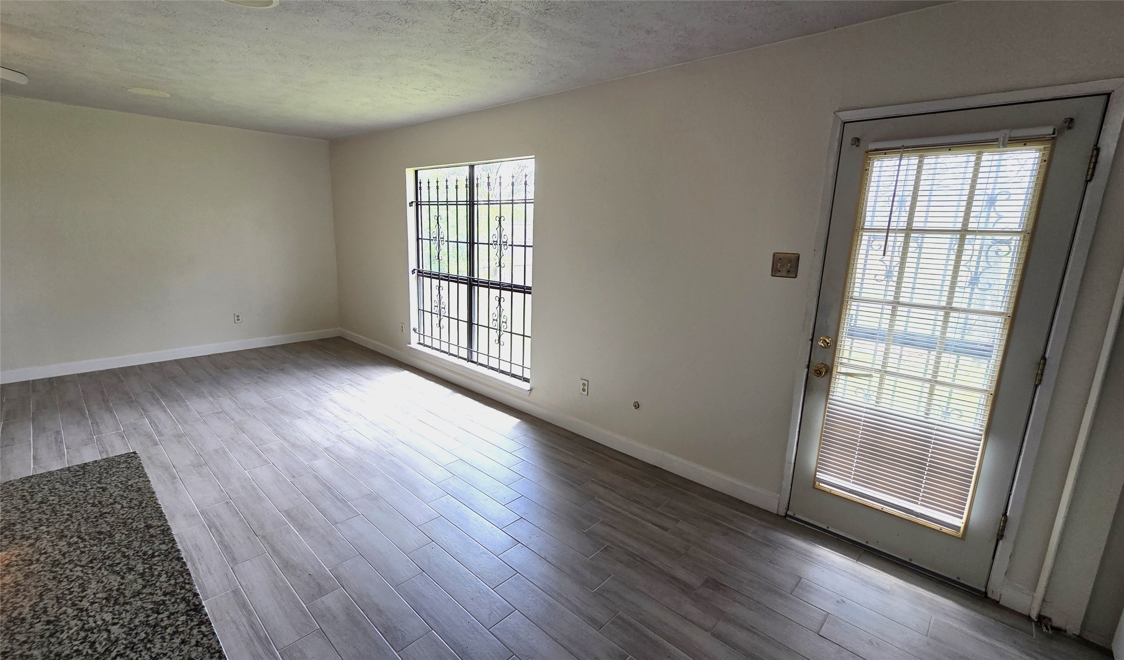 14110 Pinewest Drive Houston, TX 77049 - Photo 11 of 26 an empty room with wooden floor and windows
