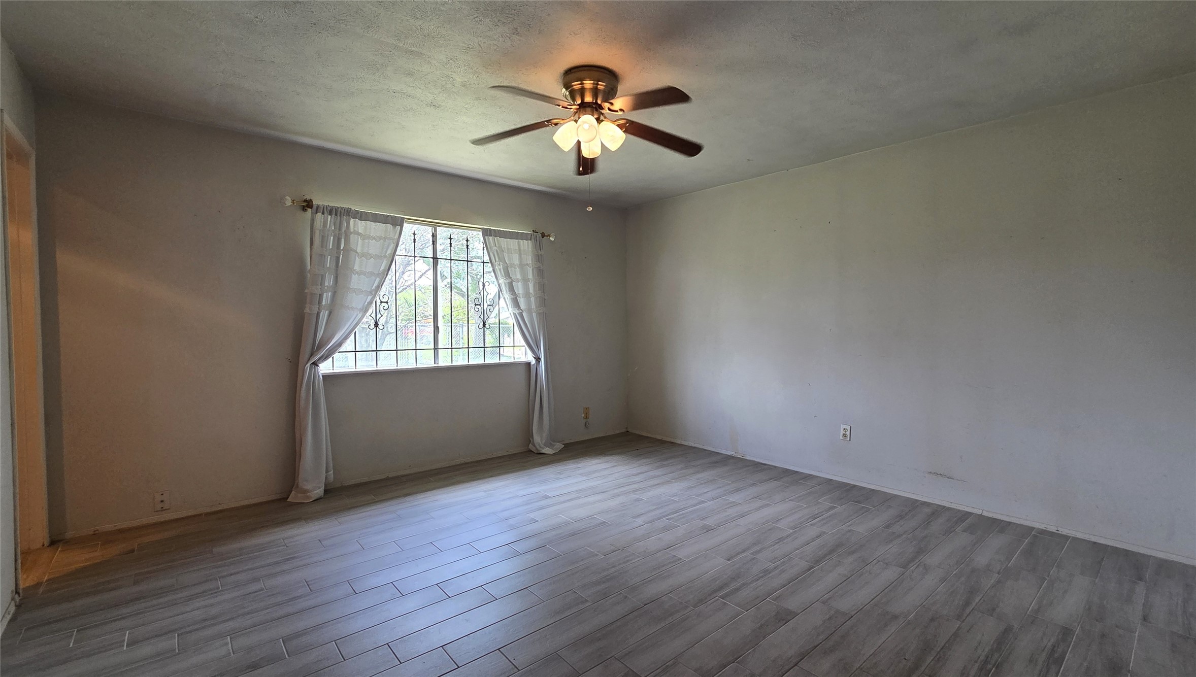 14110 Pinewest Drive Houston, TX 77049 - Photo 20 of 26 an empty room with wooden floor chandelier and windows