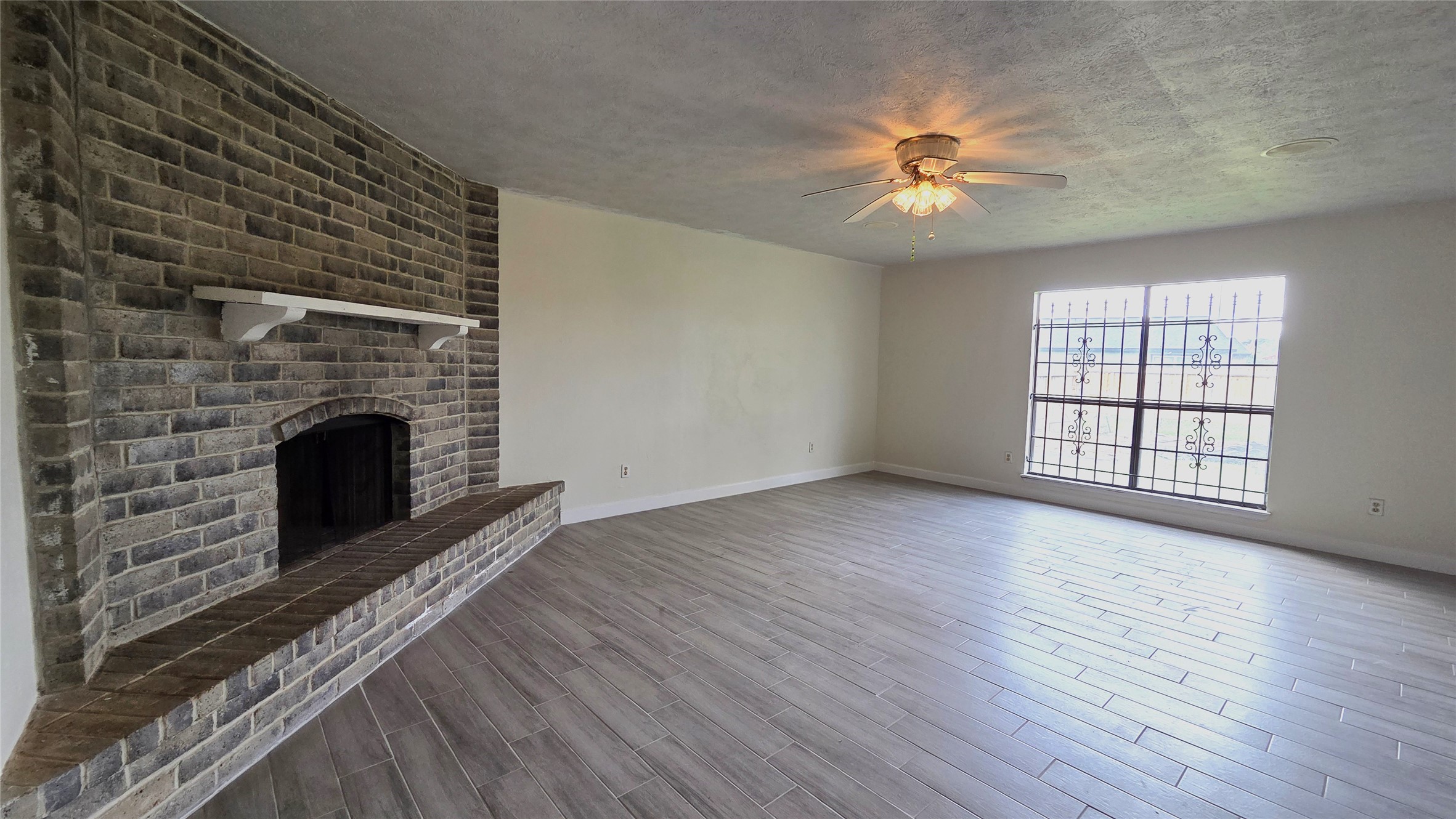 14110 Pinewest Drive Houston, TX 77049 - Photo 6 of 26 wooden floor fireplace and windows in an empty room